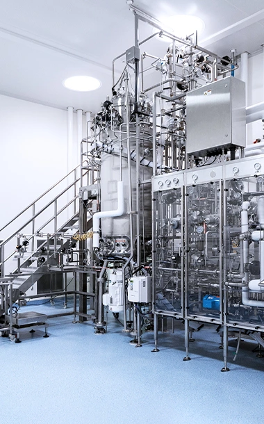 Industrial-scale microbial manufacturing bioreactor and piping infrastructure at a BioCina global CDMO facility.