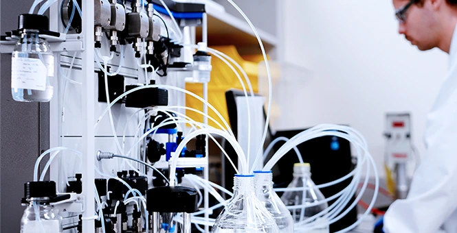 Complex tubing and fluid management systems used for bioprocess validation in a CDMO laboratory.