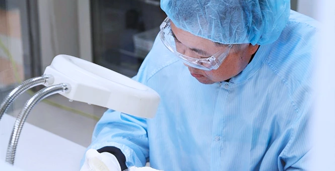 BioCina scientist performing high-precision sample inspection to ensure regulatory compliance and drug quality standards.